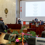 widok sali Sejmu Śląskiego - zebrani w postawie stojącej na erkanie wyświetlany teskt kolędy