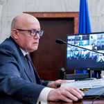 mężczyzna siedzący przed monitorami komputerów