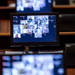 ekran monitora z wyświetlanym wizerunkiem radnych, biorących udział w sesji zdalnie
