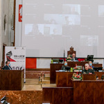 widok sali Sejmu z oddali, z mównicy przemawia mężczyzna