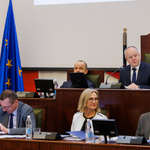 widok ław prezydium Sejmiku na środku najwyżej zasiada Przewodniczący Sejmiku poniżej zasiadają Wiceprzewodniczący