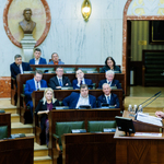 widok sali Sejmu z oddali na mównicy przemawia mężczyzna w ławach zasiadają radni