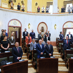 widok sali Sejmu z oddali w ławach stojący w postawie uroczystej ludzie