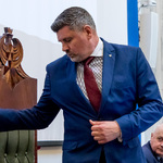mężczyzna w postawie stojącej uderza laską marszałkowską