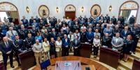 zdjęcie pamiątkowe, kilkudziesięcioro ludzi w uroczystej postawie stojącej