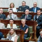 kilkoro ludzi siedzi w ławach