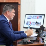 mężczyzna siedzący za biurkiem pracuje