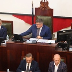 mężczyzna siedzący za biurkiem pracuje