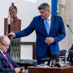 mężczyzna w postawie stojącej uderza laska marszałkowską