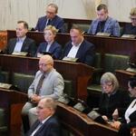 widok sali Sejmu z oddali, w ławach zasiadają ludzie