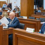 mężczyzna siedzący za biurkiem uczestniczy w obradach