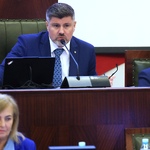 mężczyzna pracujący za biurkiem przemawia