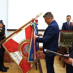 Przewodniczący Sejmiku dekoruje odznaką sztandar komendy