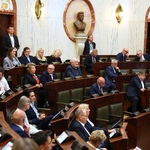 widok sali Sejmu z oddali w ławach zasiadają ludzie