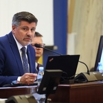 mężczyzna pracuje za biurkiem i przemawia