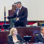 mężczyzna w postawie stojącej uderza laską marszałkowską
