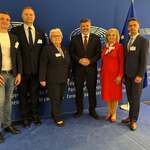 grupa osób pozuje na tle baneru Parlamentu Europejskiego